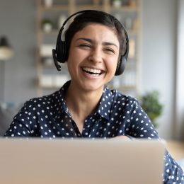 Cheerful woman wear headset laugh using laptop video stream conference call