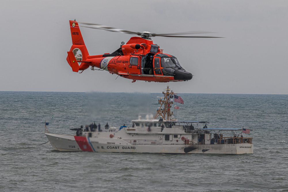 A U.S. Coast Guard helicopter and boat performing a search and rescue operation