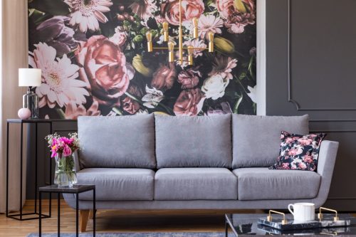 couch in front of large floral painting