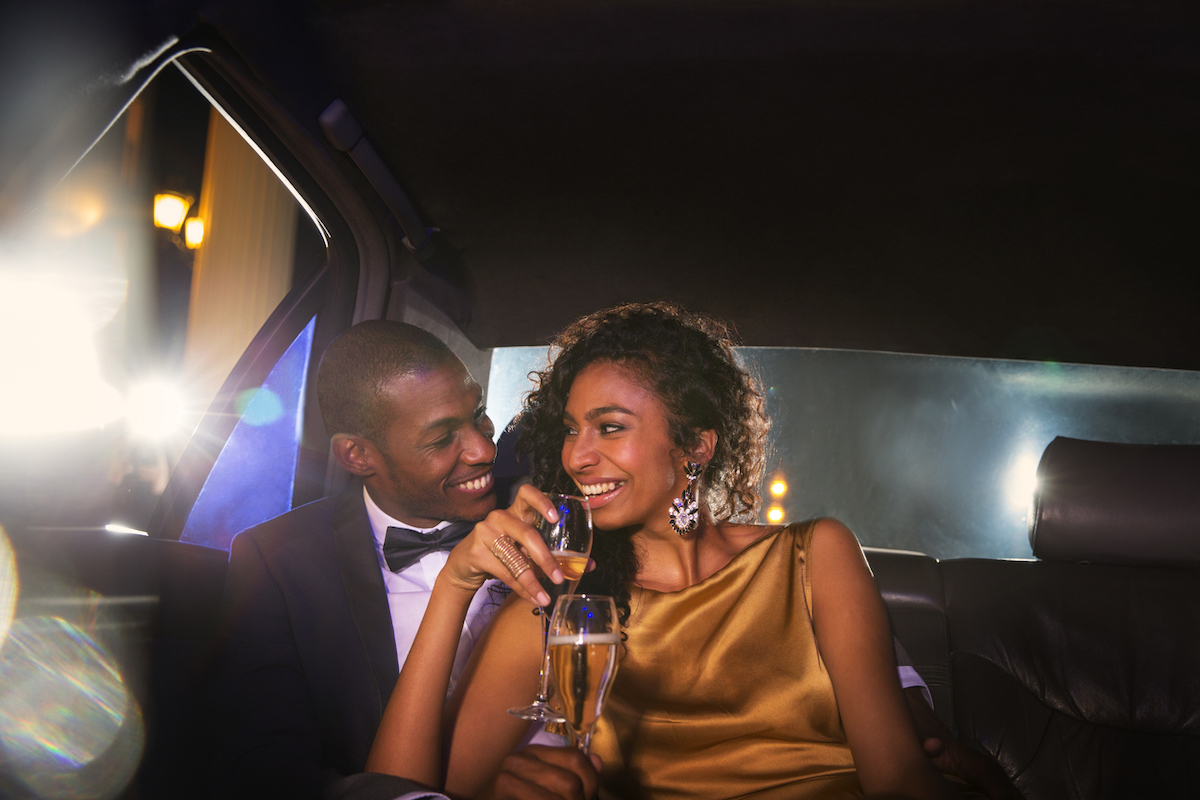 elegant couple drinking champagne in limo