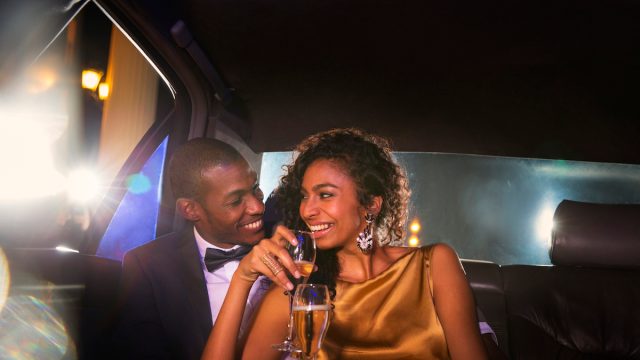 elegant couple drinking champagne in limo