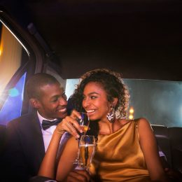elegant couple drinking champagne in limo