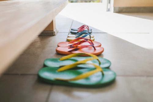 Flip-flops of family in the entrance space of modern house.