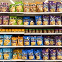 Various kinds of Tostitos products like chips and dressing stocked on shelf at retail supermarket