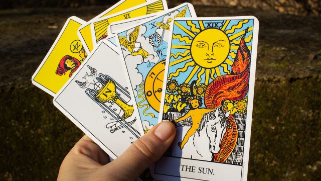 Hand holding a deck of tarot cards