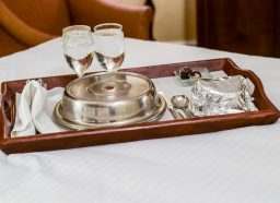 Room service tray on bed in a hotel room.