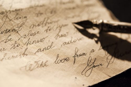 Love letter and antique quill on a black background