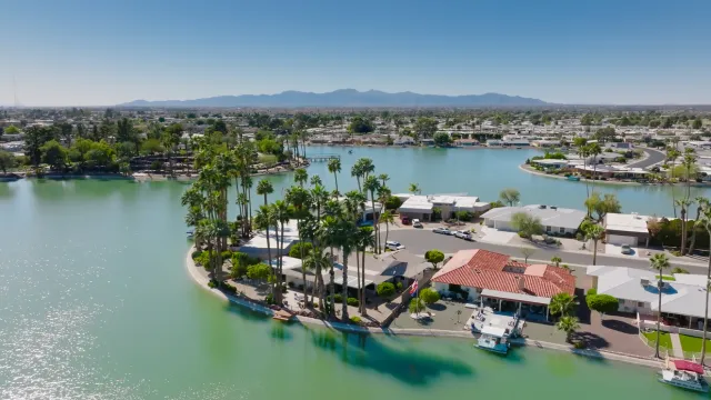 Aerial shot of houses built around an artificial lake in Sun City, an age restricted community in the metropolitan area of Phoenix, Arizona on a clear sunny day.