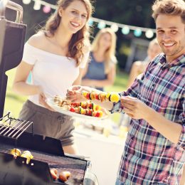 Friends having barbecue party in backyard