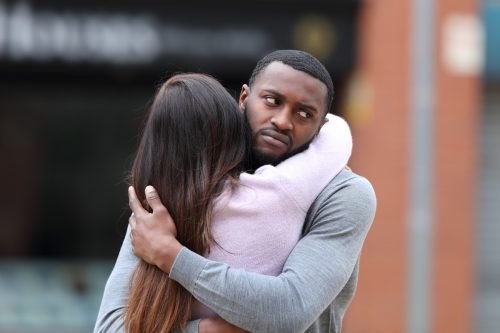 Disappointed man hugging a woman