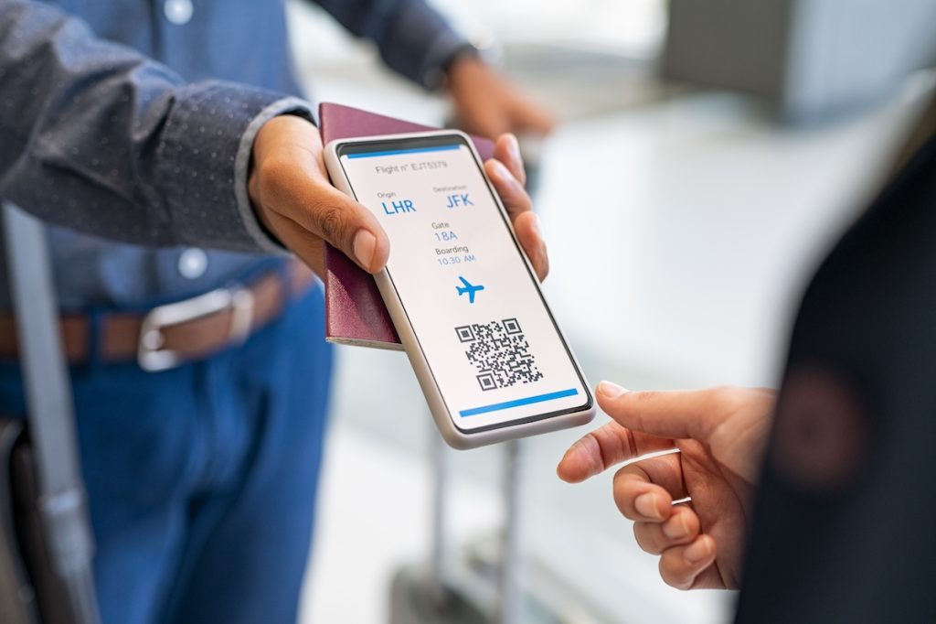 A passenger showing an electronic boarding pass to TSA agent on phone. 