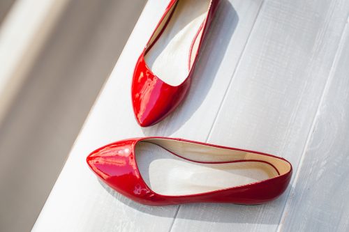 giày bệt da đỏ trên nền gỗ trắng