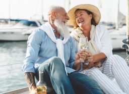 Senior couple toasting champagne on sailboat vacation