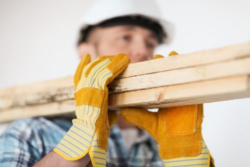 công nhân xây dựng mang ván gỗ