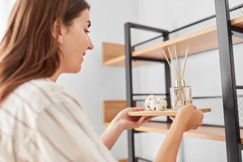 Woman placing oil diffuser on shelf