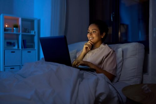 woman looking at laptop at night
