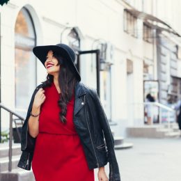 Stylish woman in the city wearing red dress and black hat