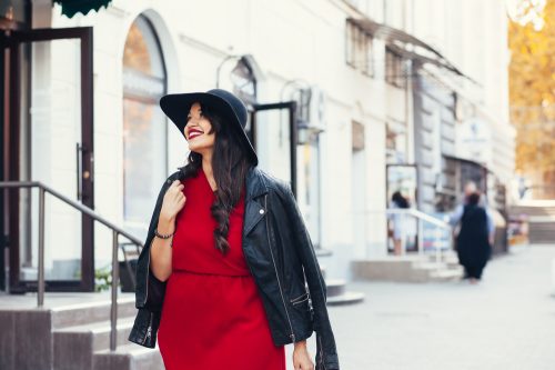Stylish woman in the city wearing red dress and black hat