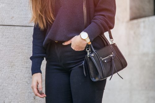 Stylish woman wearing black and navy outfit with purse
