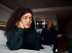 female upset with boyfriend while fighting on the sofa in modern apartment