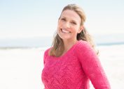 Smiling woman wearing a lovely pink top at the beach