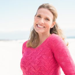 Smiling woman wearing a lovely pink top at the beach