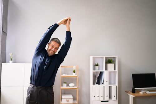 man stretching and standing tall