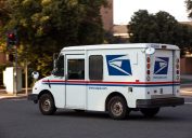 A USPS (United States Parcel Service) mail truck leaves for a delivery.