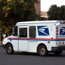 A USPS (United States Parcel Service) mail truck leaves for a delivery.