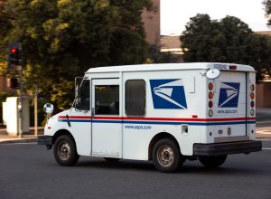 A USPS (United States Parcel Service) mail truck leaves for a delivery.