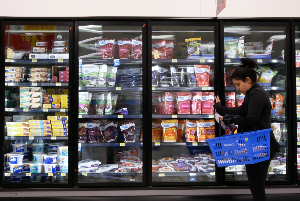 A shopper walking through the frozen food aisle at a Walmart