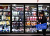 Một người mua sắm đi qua lối đi thực phẩm đông lạnh tại Walmart