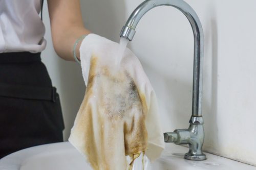 Female hand cleaning dirty rag