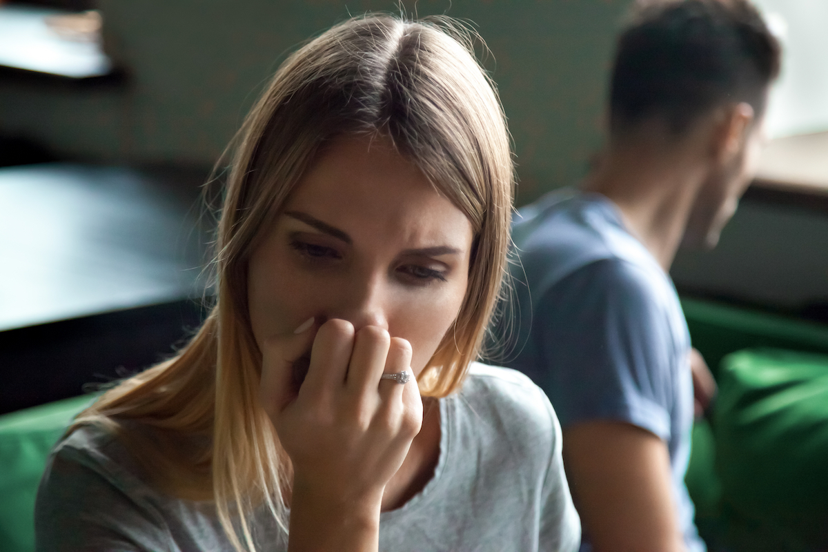 Close up portrait of upset offended frustrated woman sitting separate on couch, sofa with man at home