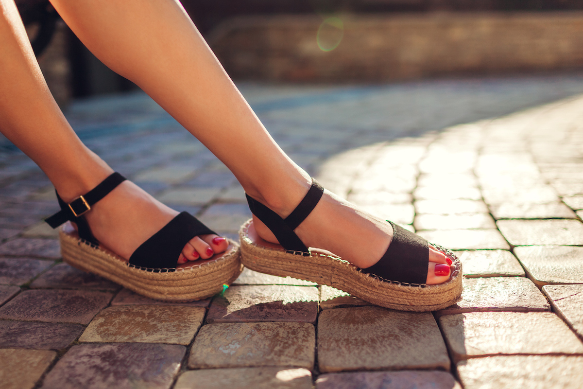 Close up of a woman's feet wearing black espadrille sandals