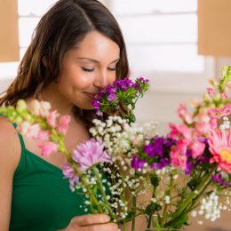 Young woman in her kitchen smelling a colorful bouquet of flowers