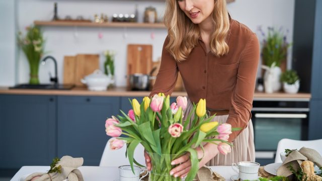 Caucasian,Woman,Putting,Vase,With,Fresh,Tulips,On,The,Table