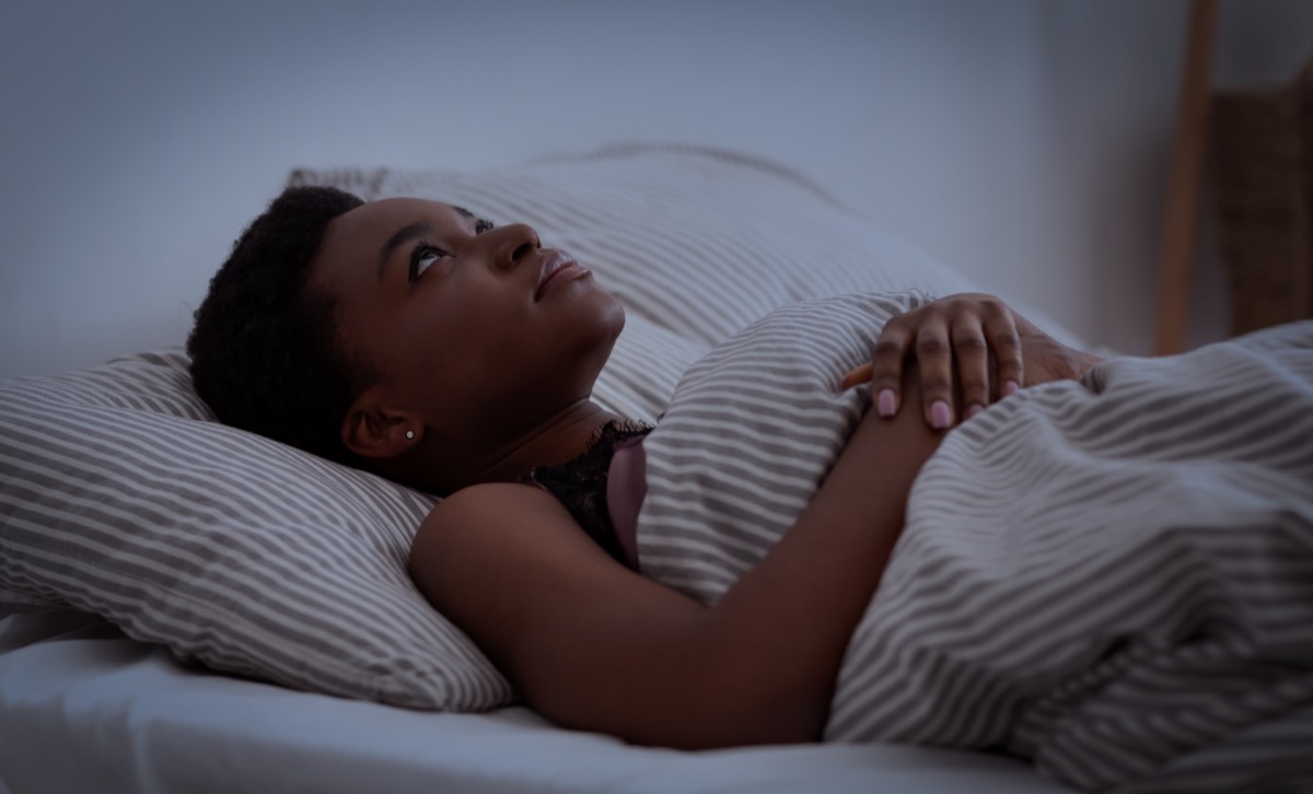 young black woman lying in bed awake at night