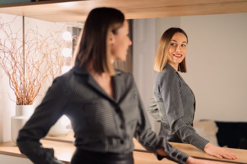 Confident Woman Looking in the Mirror