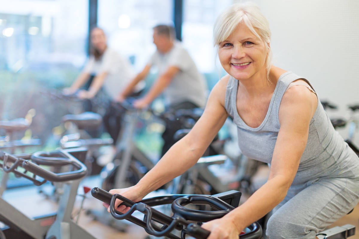 Confident seniors on exercise bikes
