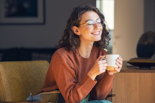 Woman Smiling and Daydreaming While Drinking Tea