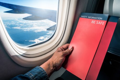 man read flight safety instructions on card board flight