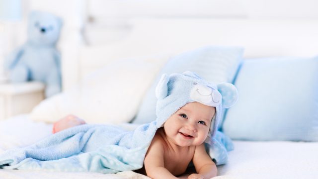 Baby boy on bed in blue robe