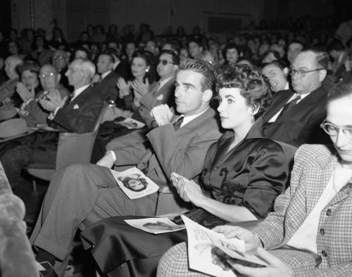 Montgomery Clift and Elizabeth Taylor watching a movie at the Palace Theater in 1951