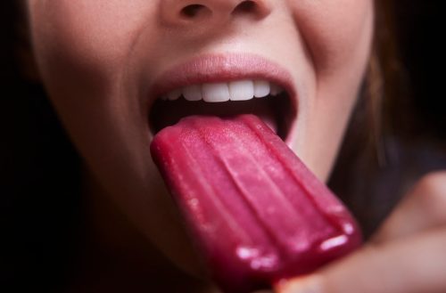 Close-up of young woman mouth red berry popsicle ice cream
