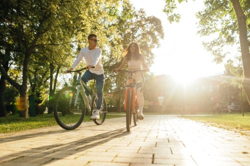 Man and woman riding bikes down a path