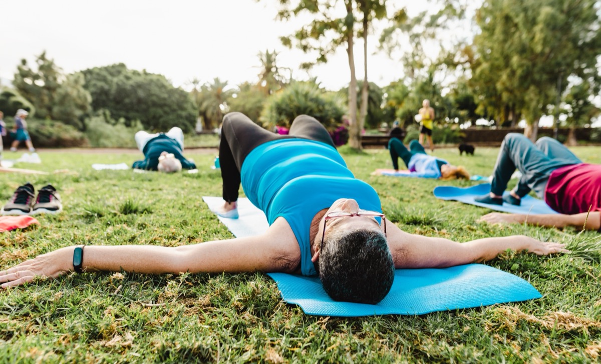woman attending a group yoga class in the park