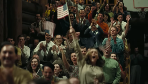 A crowd waving American flags in "Oppenheimer"