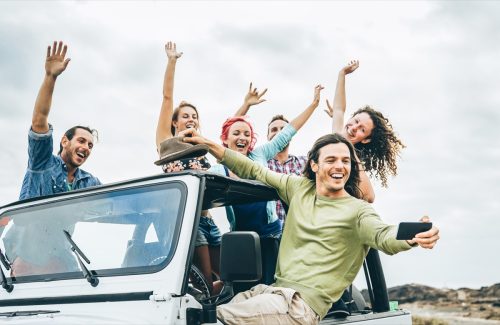 Group of young friends taking a selfie while on a road trip