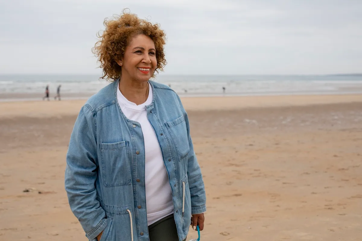 senior woman wearing denim jacket on the beach